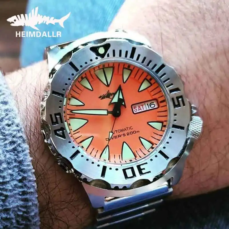 Heimdallr 62MAS Ocean Monster dive watch displaying blue luminous dial with dual-language date window and sapphire crystal face